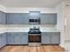 Kitchen with updated appliances, blue cabinets, mosaic backsplash, and marble countertop at 6100 Semaphore Rdg, Rex, GA 30273