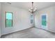 Bright, carpeted living room with natural light, complemented by an elegant chandelier and door to yard at 6100 Semaphore Rdg, Rex, GA 30273