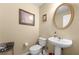 Powder room with a white pedestal sink, toilet, and framed artwork at 1536 Fenmore St, Lithia Springs, GA 30122
