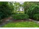 Tranquil backyard featuring stone pathways, manicured bushes and leading to a charming house at 2 W Muscogee Nw Ave, Atlanta, GA 30305