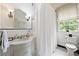 Bright bathroom featuring a marble sink, toilet, and shower with tiled walls at 2 W Muscogee Nw Ave, Atlanta, GA 30305
