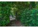 A private garden entrance with a decorative iron gate framed by lush greenery and stepping stones at 2 W Muscogee Nw Ave, Atlanta, GA 30305