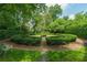 Elegant formal garden featuring manicured hedges, gravel paths, and a charming bench, surrounded by lush greenery at 2 W Muscogee Nw Ave, Atlanta, GA 30305
