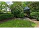 Beautiful backyard featuring a stone pathway, gazebo, manicured bushes, and lush green lawn at 2 W Muscogee Nw Ave, Atlanta, GA 30305