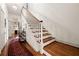 Bright entry hallway featuring hardwood floors, stairs, and an ornate patterned rug at 2 W Muscogee Nw Ave, Atlanta, GA 30305
