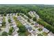 An aerial view of homes in a tree-lined neighborhood showcases community layout, greenery, and varied housing styles at 2530 Vistoria Dr, Cumming, GA 30041