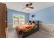 Bright bedroom with large window, featuring a ceiling fan and playful decor for a cheerful ambiance at 2530 Vistoria Dr, Cumming, GA 30041