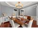 Spacious dining room with hardwood floors, elegant chandelier, and classic wainscoting at 2530 Vistoria Dr, Cumming, GA 30041