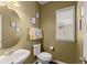 Cozy powder room with decorative mirror, updated vanity, and a window for natural light at 2530 Vistoria Dr, Cumming, GA 30041