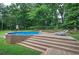 Backyard with an above ground pool surrounded by a wooden deck and lush landscaping at 123 Mill Ln, Dallas, GA 30157