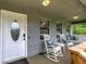 Charming covered porch featuring rocking chairs, swing, and a decorative door at 123 Mill Ln, Dallas, GA 30157