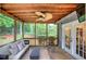 Relax in this screened porch with a wood ceiling, ceiling fan, and view of the trees at 123 Mill Ln, Dallas, GA 30157