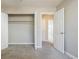 This carpeted bedroom features an open closet with rods and an open door with access to other rooms at 3312 Northcrest Rd # A, Atlanta, GA 30340