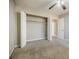 This bedroom features carpet, a ceiling fan, an open closet, and an open door at 3312 Northcrest Rd # A, Atlanta, GA 30340