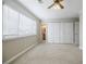 Bright bedroom featuring a large window, blinds, carpet, and a closet with bi-fold doors at 3312 Northcrest Rd # A, Atlanta, GA 30340