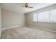 This bedroom is brightly lit from the window and features carpet and a ceiling fan at 3312 Northcrest Rd # A, Atlanta, GA 30340
