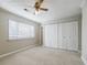 Large bedroom with a window, carpet, a ceiling fan, and a closet with doors at 3312 Northcrest Rd # A, Atlanta, GA 30340