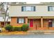 Two-story townhouse with brick facade, tan siding, black shutters, and a vibrant red front door for eye-catching curb appeal at 3312 Northcrest Rd # A, Atlanta, GA 30340
