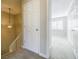 Hallway with a stairway, carpeted floor, and a bedroom door leading to a room with lots of light at 3312 Northcrest Rd # A, Atlanta, GA 30340