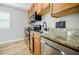 Galley kitchen featuring wood cabinetry, granite countertops, and stainless steel appliances at 3312 Northcrest Rd # A, Atlanta, GA 30340