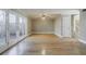 Large living room with hardwood floors, neutral walls, ceiling fan, and access to a fenced backyard through double French doors at 3312 Northcrest Rd # A, Atlanta, GA 30340