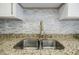 Close up of the kitchen sink with granite countertops and tile backsplash at 3318 Northcrest Rd # D, Atlanta, GA 30340