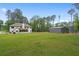 Expansive backyard featuring a well-maintained lawn, modern home, barn and lush trees, offering plenty of space at 337 Paynes Lake Rd, Carrollton, GA 30116