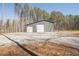 Modern gray barn featuring two large garage doors and ample parking space for vehicles and equipment at 337 Paynes Lake Rd, Carrollton, GA 30116