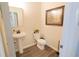Small bathroom features a pedestal sink, toilet and wood look floors with an framed print hanging on the wall at 337 Paynes Lake Rd, Carrollton, GA 30116