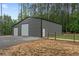 A large steel building with two roll-up doors and a walk-in door at 337 Paynes Lake Rd, Carrollton, GA 30116