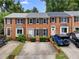 Attractive brick townhomes with black shutters and trimmed bushes, with ample parking on concrete driveway at 2779 Bentley Se Pl, Marietta, GA 30067