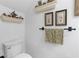Bright powder room with decorative shelving, framed art, and a patterned towel at 2779 Bentley Se Pl, Marietta, GA 30067