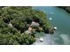 An aerial view showcases the waterfront property with lush greenery, a private dock and boat lifts at 7815 Bamby Rd, Cumming, GA 30041
