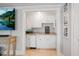A cute butler's pantry with white cabinets, tan countertops, and a small refrigerator at 7815 Bamby Rd, Cumming, GA 30041