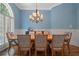Elegant dining room featuring a stylish chandelier, blue walls, and patterned chairs at 7815 Bamby Rd, Cumming, GA 30041