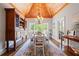 Dining room with a wood ceiling, hardwood floors, and a large window with views of the backyard at 7815 Bamby Rd, Cumming, GA 30041