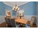 This dining room features wood floors, wainscoting, and a chandelier, exuding a classic and inviting ambiance at 7815 Bamby Rd, Cumming, GA 30041
