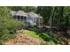 Multi-level home with stone and wood accents, a backyard patio, and mature trees provide a luxurious and private setting at 7815 Bamby Rd, Cumming, GA 30041