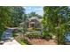 Beautiful home exterior surrounded by lush trees and landscaping, featuring a long driveway and well-maintained lawn at 7815 Bamby Rd, Cumming, GA 30041