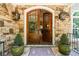 Elegant stone entryway and wood double doors with decorative lanterns at 7815 Bamby Rd, Cumming, GA 30041