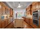 Well-lit kitchen with hardwood floors, stainless appliances, granite countertops, and custom wood cabinetry at 7815 Bamby Rd, Cumming, GA 30041