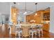 Large open kitchen with an island, granite countertops, custom cabinets, and hardwood floors at 7815 Bamby Rd, Cumming, GA 30041