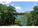 Picturesque lake view framed by mature trees, perfect for enjoying the natural beauty of the waterfront at 7815 Bamby Rd, Cumming, GA 30041
