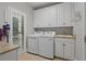 Well-equipped laundry room features modern washer, dryer, granite counters, sink, and convenient storage at 7815 Bamby Rd, Cumming, GA 30041