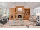 Bright living room with vaulted ceilings, a stone fireplace, hardwood floors, and lots of natural light at 7815 Bamby Rd, Cumming, GA 30041