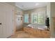 Bright bathroom featuring a soaking tub, glass shower, and ample natural light at 7815 Bamby Rd, Cumming, GA 30041