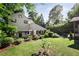Expansive backyard with manicured lawn, mature trees, and a view of the home's exterior at 820 Highland Ne Ter, Atlanta, GA 30306