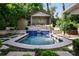 Backyard swimming pool surrounded by stone pavers, lush landscaping, and a pergola at 820 Highland Ne Ter, Atlanta, GA 30306