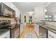 Modern kitchen leading into breakfast nook; features stainless appliances and black countertops at 117 Laguna Springs Dr, Woodstock, GA 30188
