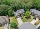 Aerial view of a beautiful home with a long driveway nestled among lush green trees in a residential neighborhood at 117 Willow View Ln, Canton, GA 30114